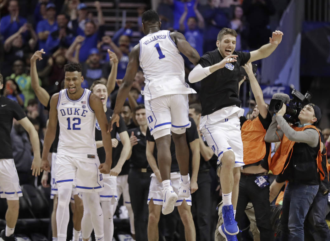 Duke players including Javin DeLaurier (12) and Zion Williamson (1) celebrate after defeating Florida State in the NCAA college basketball championship game of the Atlantic Coast Conference tourna ...