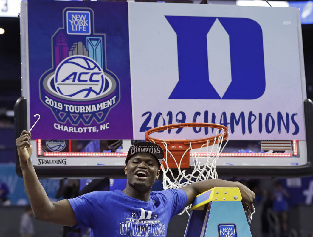Duke's Zion Williamson celebrates Duke's win over Florida State after cutting a piece of a net after the NCAA college basketball championship game of the Atlantic Coast Conference tournament in Ch ...