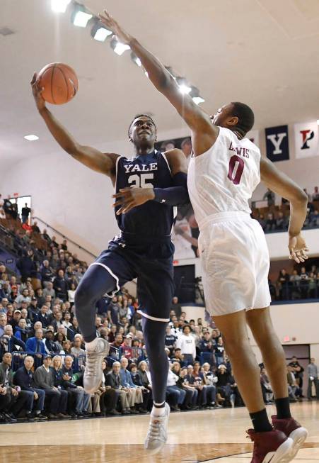 Yale's Miye Oni, left, shoots as Harvard's Chris Lewis, right, defends during the first half of an NCAA college basketball game in a for the Ivy League championship at Yale University in New Haven ...