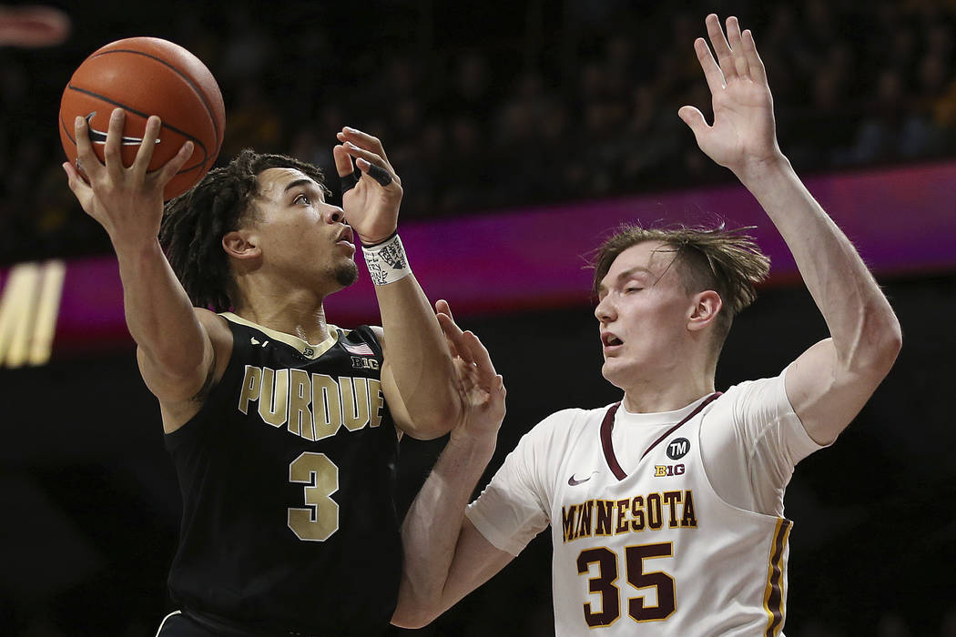 Purdue's Carsen Edwards, left, goes up to the hoop against Minnesota's center Matz Stockman, right, during the second half of an NCAA basketball game Tuesday, March 5, 2019, in Minneapolis. Minnes ...