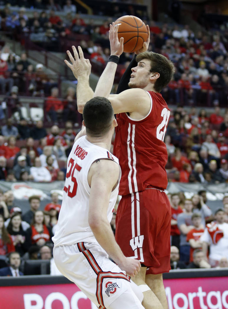 Wisconsin forward Ethan Happ, right, goes up for a shot against Ohio State forward Kyle Young during an NCAA college basketball game in Columbus, Ohio, Sunday, March 10, 2019. Wisconsin won 73-67 ...