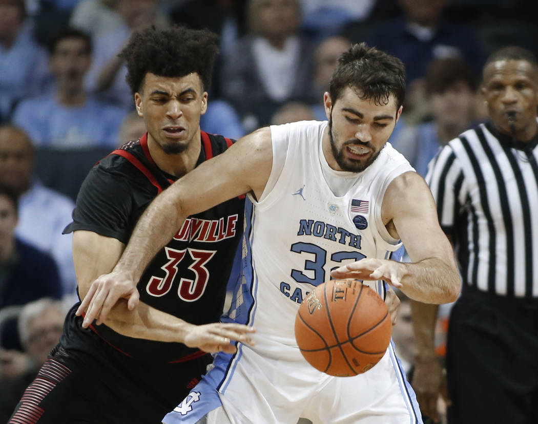 Louisville's Jordan Nwora (33) tries to steal the ball from North Carolina's Luke Maye (32) during the first half of an NCAA college basketball game in the Atlantic Coast Conference tournament in ...