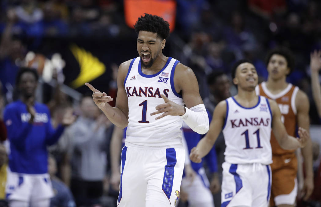 Kansas' Dedric Lawson (1) and Devon Dotson (11) celebrate after Dotson made a 3-point shot during the second half against Texas in an NCAA college basketball game in the Big 12 men's tournament Th ...