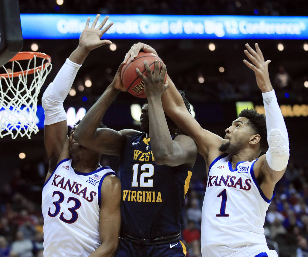 Kansas forward Dedric Lawson (1) blocks a shot by West Virginia forward Andrew Gordon (12) during the second half of an NCAA college basketball game in the semifinals of the Big 12 men's tournamen ...