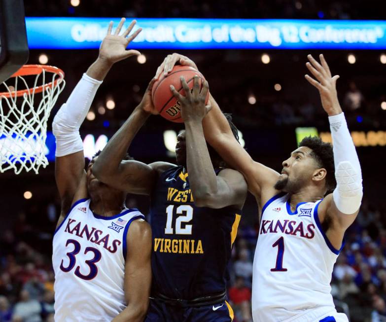 Kansas forward Dedric Lawson (1) blocks a shot by West Virginia forward Andrew Gordon (12) during the second half of an NCAA college basketball game in the semifinals of the Big 12 men's tournamen ...