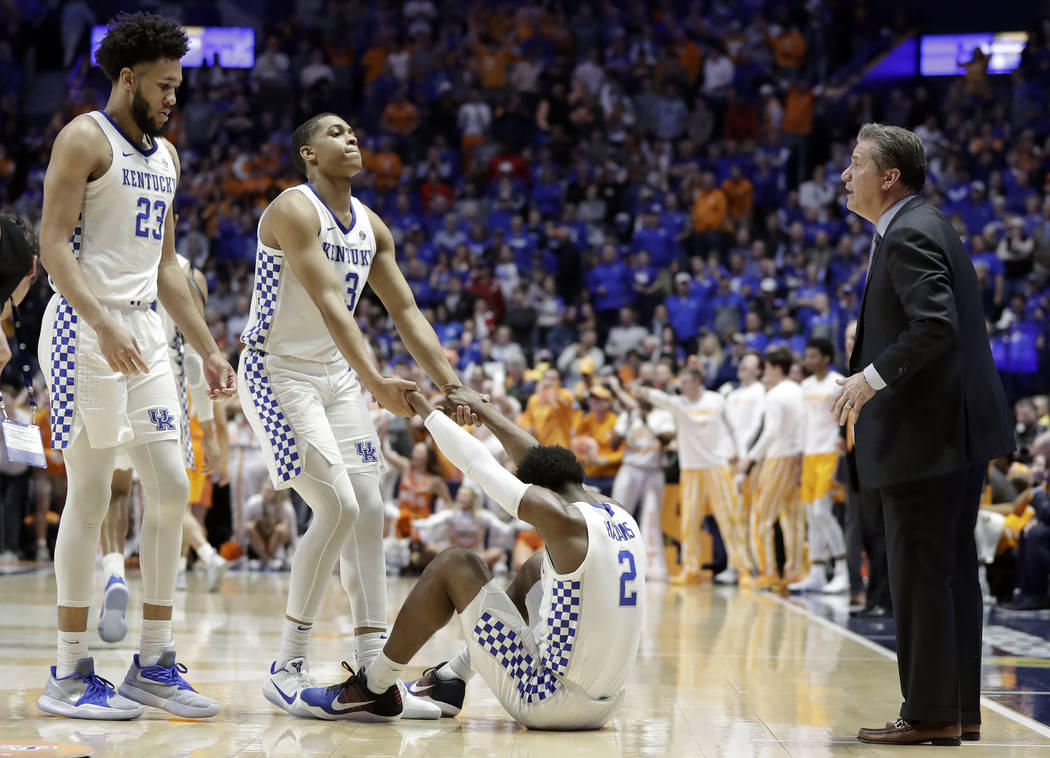 Kentucky guard Ashton Hagans (2) is helped up by Keldon Johnson (3) after Hagans was called for a foul in the final minute of an NCAA college basketball game against Tennessee at the Southeastern ...