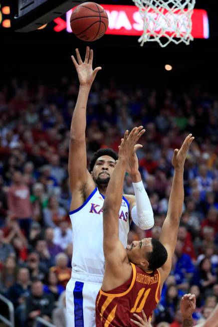 Kansas forward Dedric Lawson, back, shoots over Iowa State guard Talen Horton-Tucker (11) during the first half of an NCAA college basketball game in the finals of the Big 12 conference tournament ...