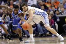 Duke's Zion Williamson, left, and North Carolina's Luke Maye, right, chase a loose ball during the first half of an NCAA college basketball game in the Atlantic Coast Conference tournament in Char ...
