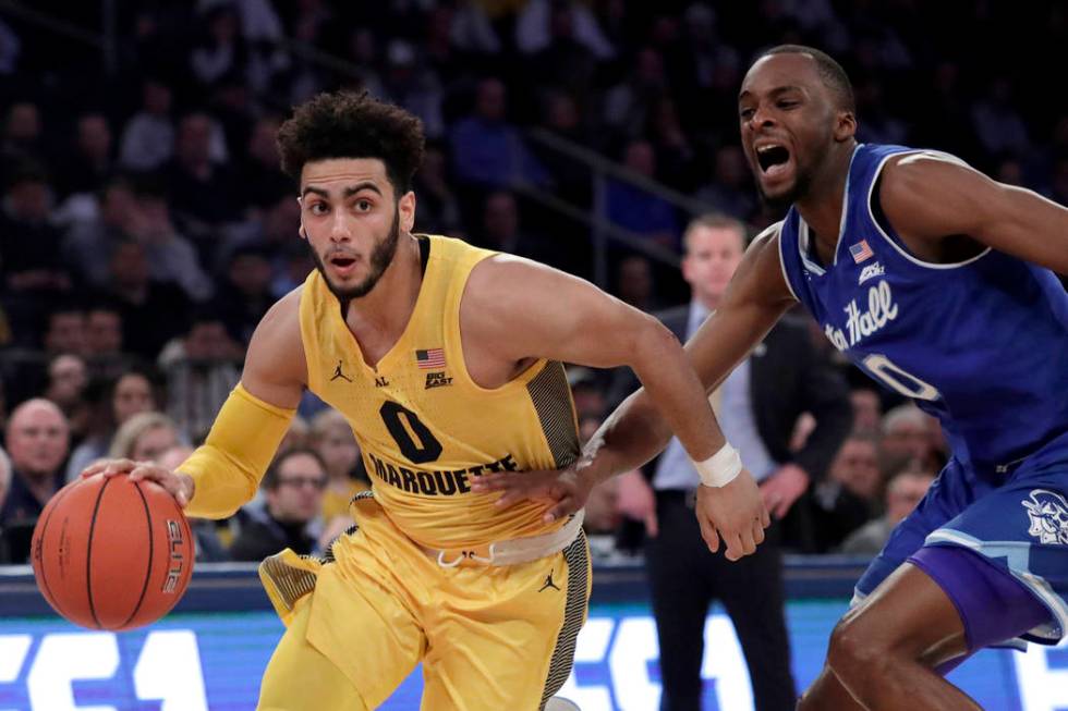 Marquette guard Markus Howard (0) drives against Seton Hall guard Quincy McKnight (0) during the first half of an NCAA college basketball semifinal game in the Big East men's tournament, Friday, M ...