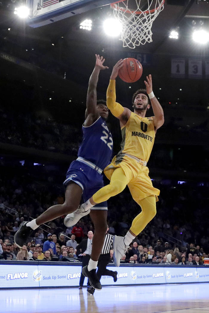 Marquette guard Markus Howard (0) goes up for a shot against Seton Hall guard Myles Cale (22) during the first half of an NCAA college basketball semifinal game in the Big East men's tournament, F ...