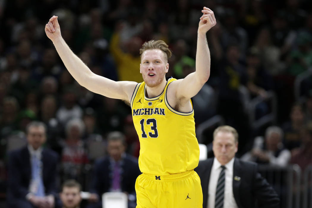 Michigan's Ignas Brazdeikis (13) reacts after shooting a 3-point basket during the first half of an NCAA college basketball championship game against Michigan State in the Big Ten Conference tourn ...
