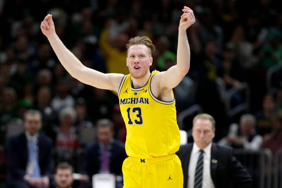 Michigan's Ignas Brazdeikis (13) reacts after shooting a 3-point basket during the first half of an NCAA college basketball championship game against Michigan State in the Big Ten Conference tourn ...