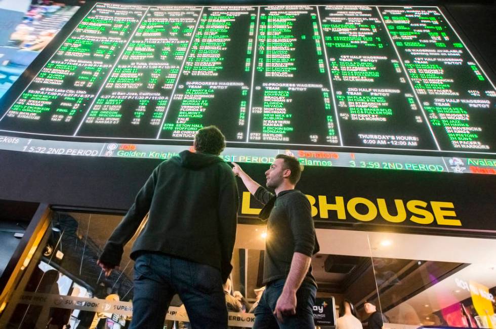 Evan Thoma, right, and Matt Castagna, both from Chicago, Ill., discuss odds during the first day of the NCAA Tournament at the Westgate Sportsbook on Thursday, March 21, 2019, at Westgate, in Las ...