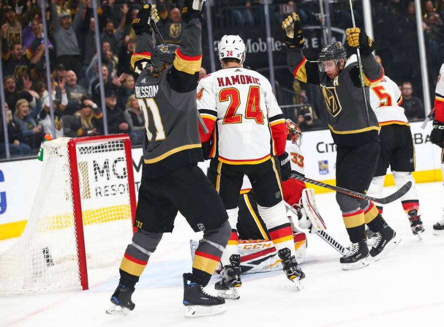 Golden Knights center William Karlsson (71) and right wing Reilly Smith celebrate a goal by defenseman Shea Theodore, not pictured, during the first period of an NHL hockey game at T-Mobile Arena ...