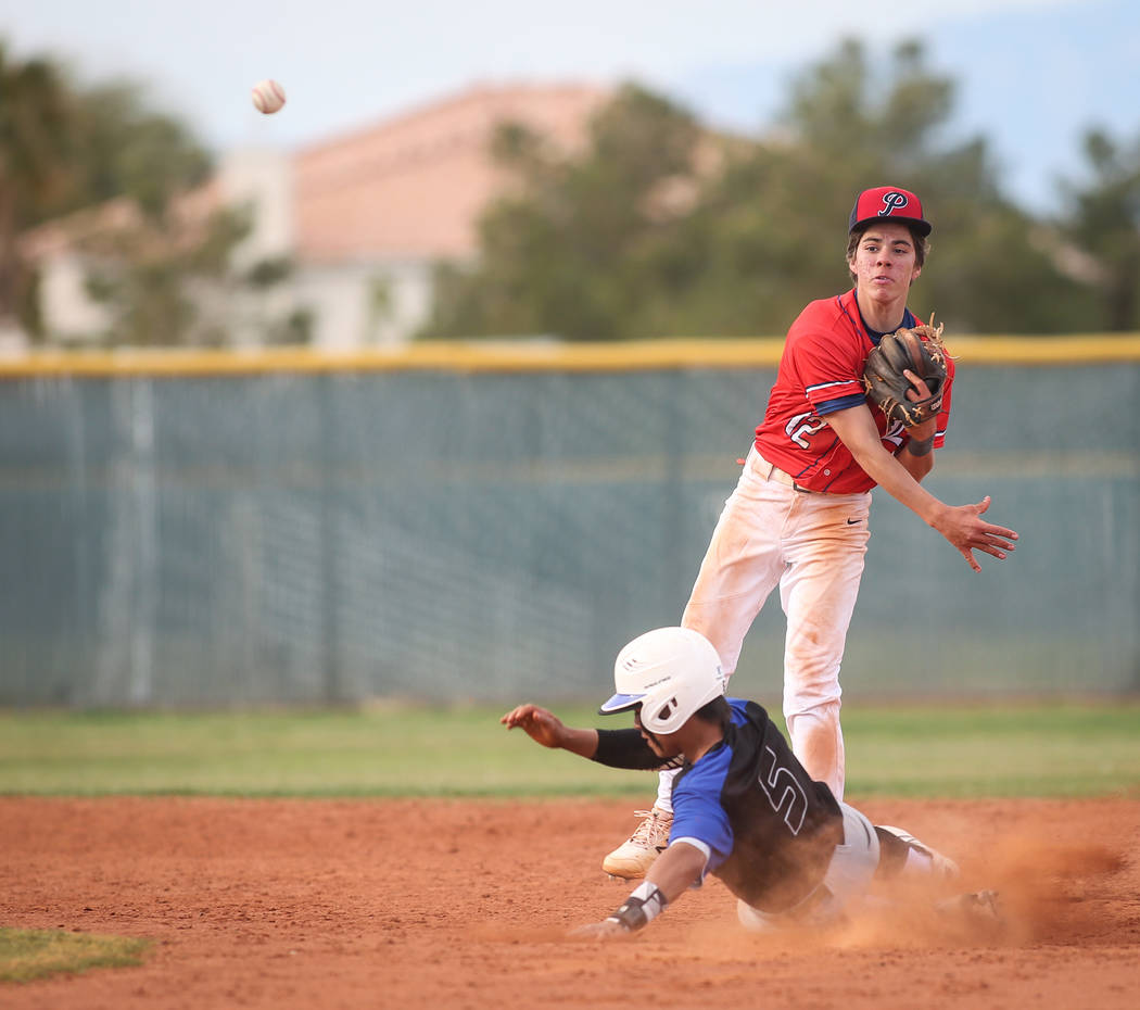 Liberty's Jack Hale (12) passes to first base after getting out Basic's Dominik Tavares (5) in the sixth inning of a baseball game at Liberty High School in Henderson, Tuesday, March 19, 2019. (Ca ...