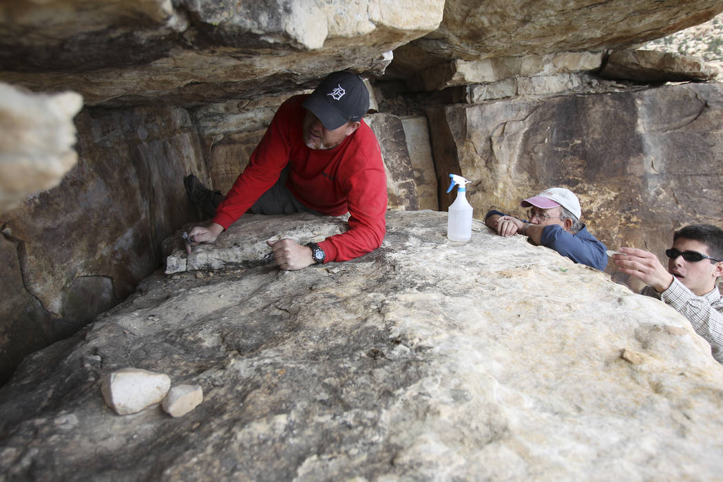 Klaus Cobb, a volunteer with Friends of Red Rock Canyon, left, works Thursday, May 19, 2011, to restore an ancient rock art site in Red Rock Canyon National Conservation Area that was damaged by g ...