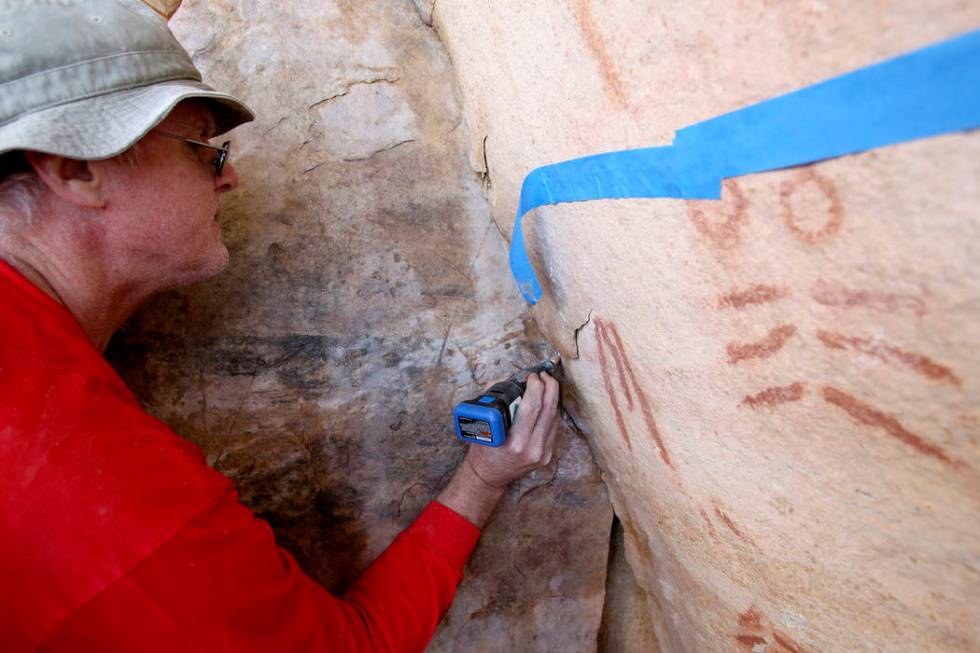 Wyatt Mulvey, a volunteer with Friends of Red Rock Canyon, works Thursday, May 19, 2011, to restore an ancient rock art site near Lost Creek that was damaged by graffiti vandals in November. (K.M ...