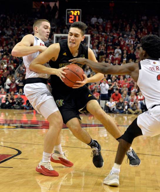 Vermont guard Robin Duncan (4) attempts to drive between Louisville guard Ryan McMahon, left, and guard Darius Perry during the first half of an NCAA college basketball game in Louisville, Ky., Fr ...