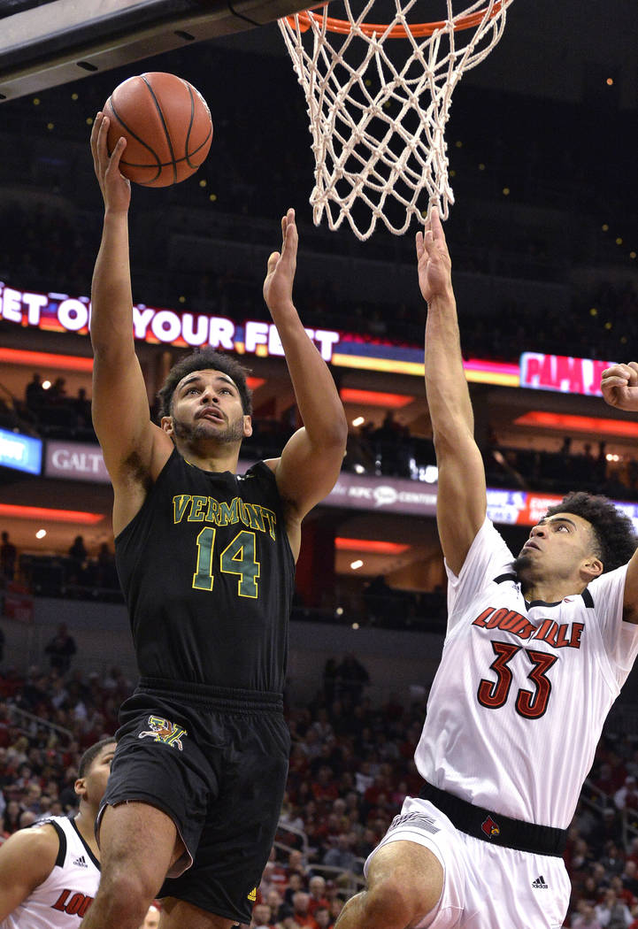 Vermont forward Isaiah Moll (14) shoots as Louisville forward Jordan Nwora (33) defends during the first half of an NCAA college basketball game in Louisville, Ky., Friday, Nov. 16, 2018. (AP Phot ...
