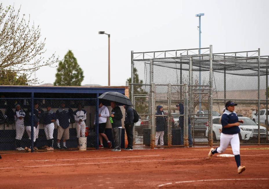Shadow Ridge players keep cover from rain in the dugout as a softball game against Centennial is delayed at Shadow Ridge High School in Las Vegas on Wednesday, March 20, 2019. (Chase Stevens/Las V ...
