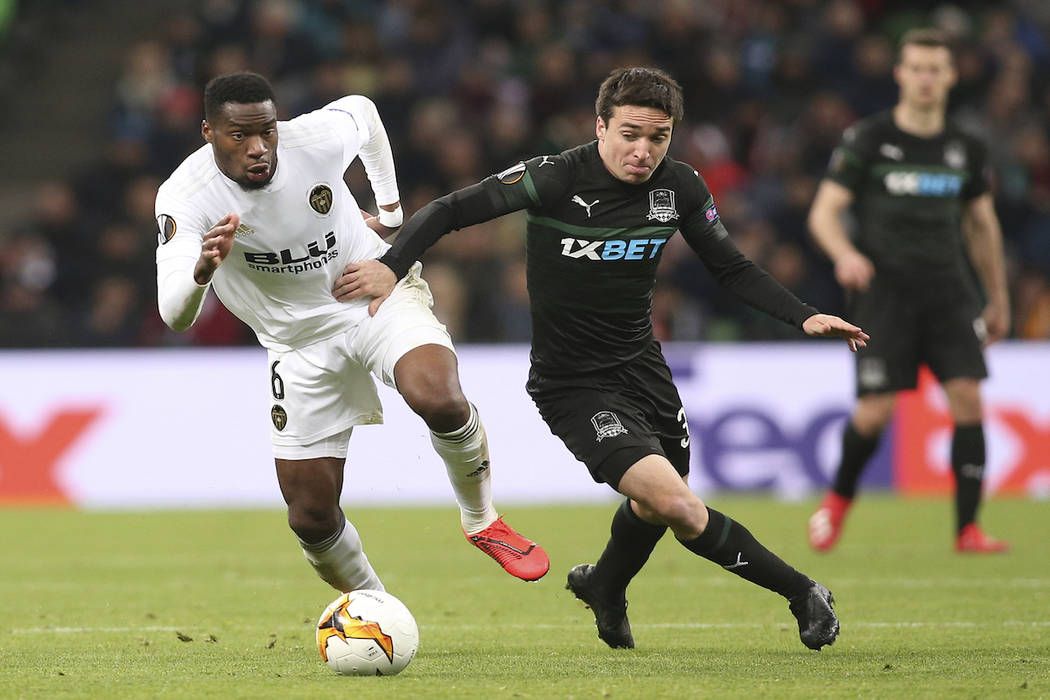 Valencia's Geoffrey Kondogbia, left, and Krasnodar's Mauricio Pereyra challenge for the ball during the Europa League round of 16, second leg soccer match between FC Krasnodar and Valencia at the ...