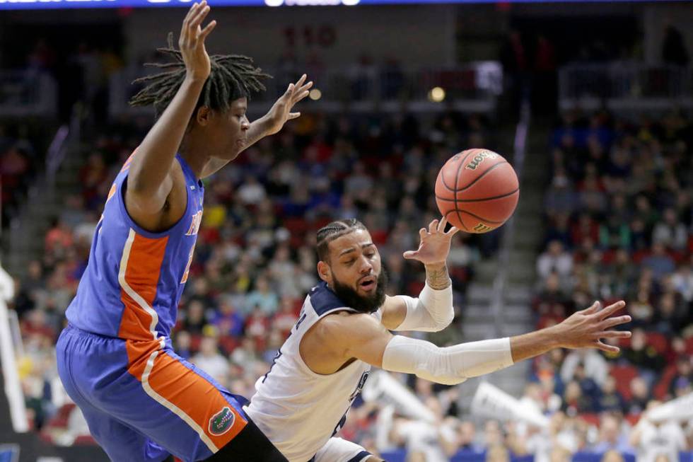 Nevada's Cody Martin, right, loses control of the ball as he drives around Florida's Andrew Fava, left, during the first half of a first round men's college basketball game in the NCAA Tournament ...