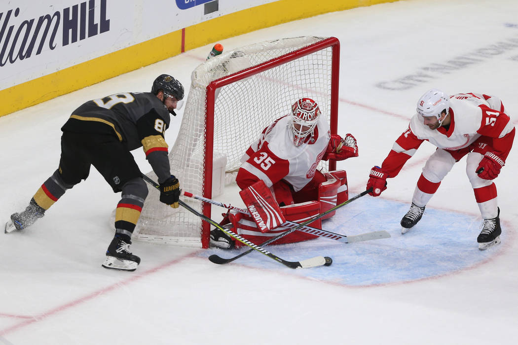 Vegas Golden Knights right wing Alex Tuch (89) fights for the puck against Detroit Red Wings center Frans Nielsen (51) and goaltender Jimmy Howard (35) during the third period of an NHL hockey gam ...