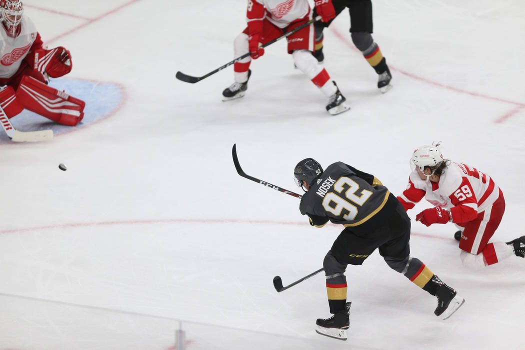 Vegas Golden Knights left wing Tomas Nosek (92) takes a shot under pressure from Detroit Red Wings left wing Tyler Bertuzzi (59) during the third period of an NHL hockey game at T-Mobile Arena in ...