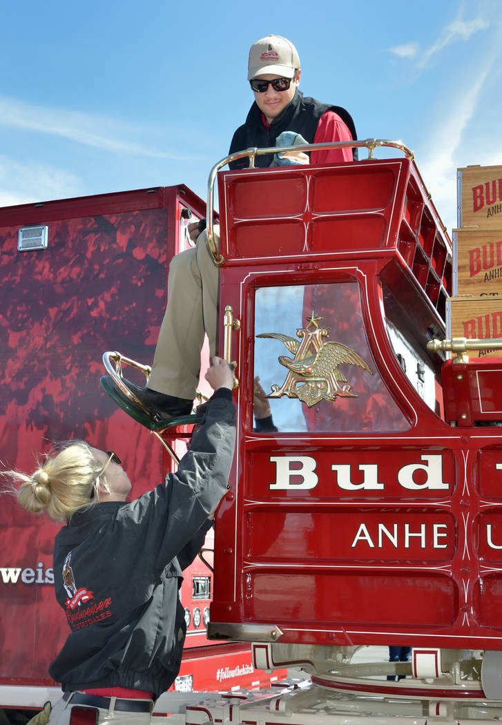 Handlers Lauren Lambeth, left, and Andrew LaCrosse polish the brass on the beer wagon during a visit by the Budweiser Clydesdales to the Smith’s Marketplace at 9710 W. Skye Canyon Park Driv ...