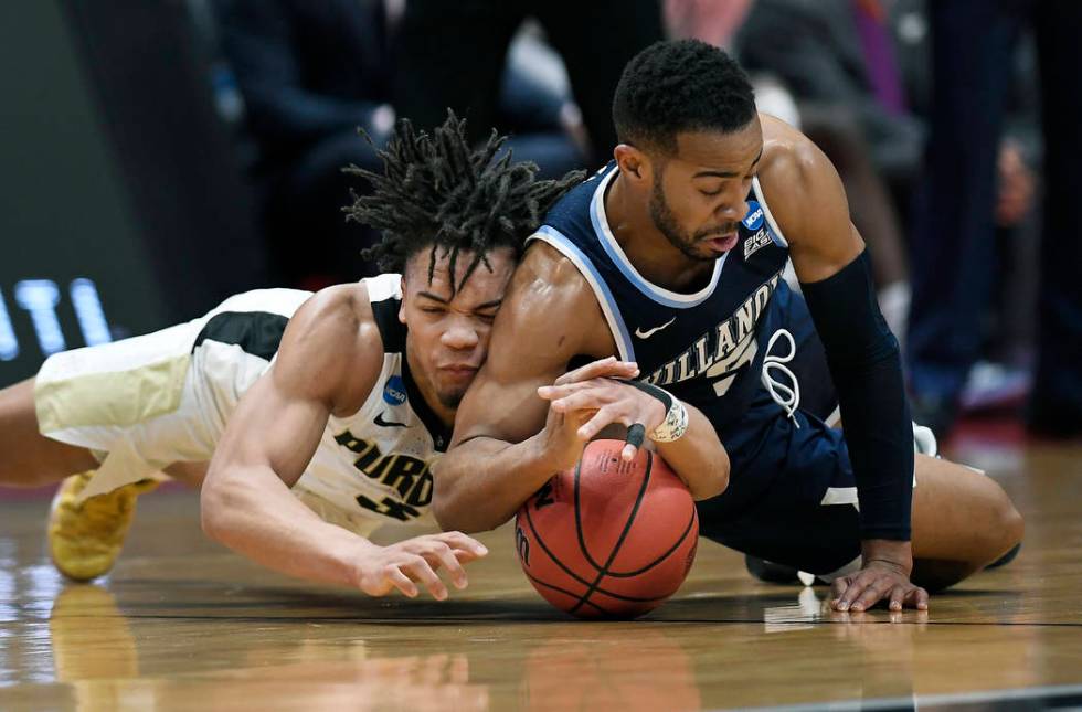 Purdue's Carsen Edwards, left, and Villanova's Phil Booth dive for a loose ball during the first half of a second round men's college basketball game in the NCAA tournament, Saturday, March 23, 20 ...