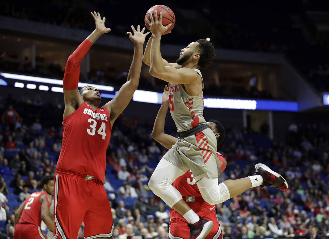 Houston's Galen Robinson Jr., right, heads to the basket as Ohio State's Kaleb Wesson (34) defends during the second half of a second round men's college basketball game in the NCAA Tournament Sun ...