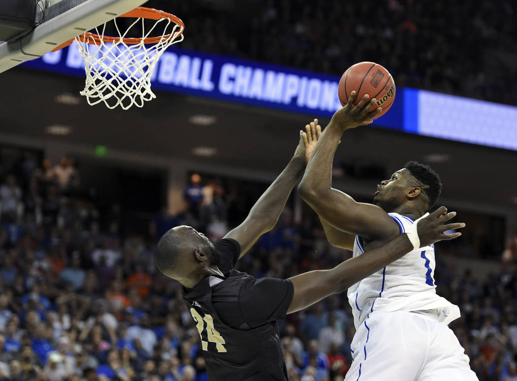 Duke's Zion Williamson, right, shoots over Central Florida's Tacko Fall during the second half of a second-round men's college basketball game in the NCAA Tournament in Columbia, S.C. Sunday, Marc ...