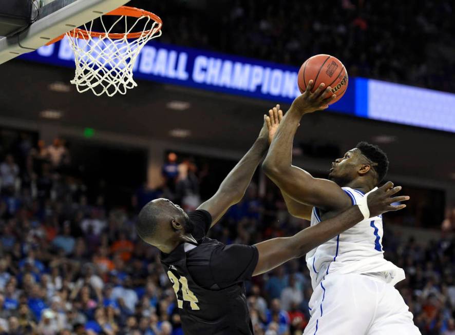Duke's Zion Williamson, right, shoots over Central Florida's Tacko Fall during the second half of a second-round men's college basketball game in the NCAA Tournament in Columbia, S.C. Sunday, Marc ...