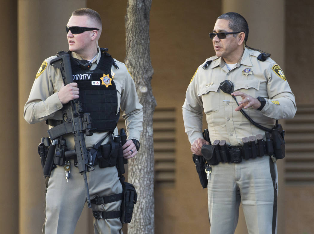 Metro officer Dallin Van Buskirk, left, armed with an AR-15 semi-automatic rifle with a scope, ...