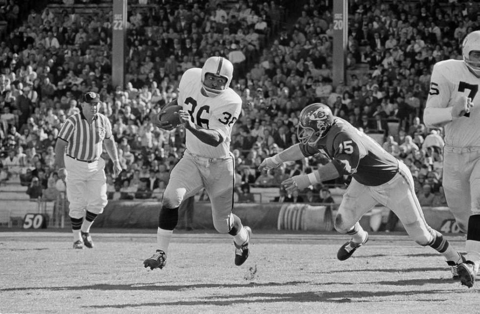 Clem Daniels (36) of the Oakland Raiders races around the right side of his line as Jerry Mays, right, of the Kansas City Chiefs moves in for the tackle, in Kansas City, Mo. on Oct. 31, 1965. (AP ...