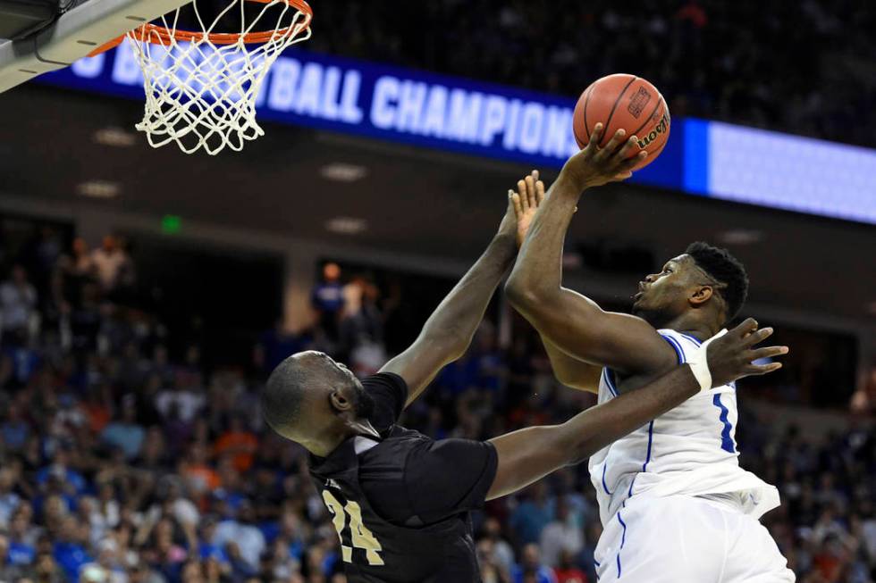 Duke's Zion Williamson, right, shoots over Central Florida's Tacko Fall during the second half of a second-round men's college basketball game in the NCAA Tournament in Columbia, S.C. Sunday, Marc ...