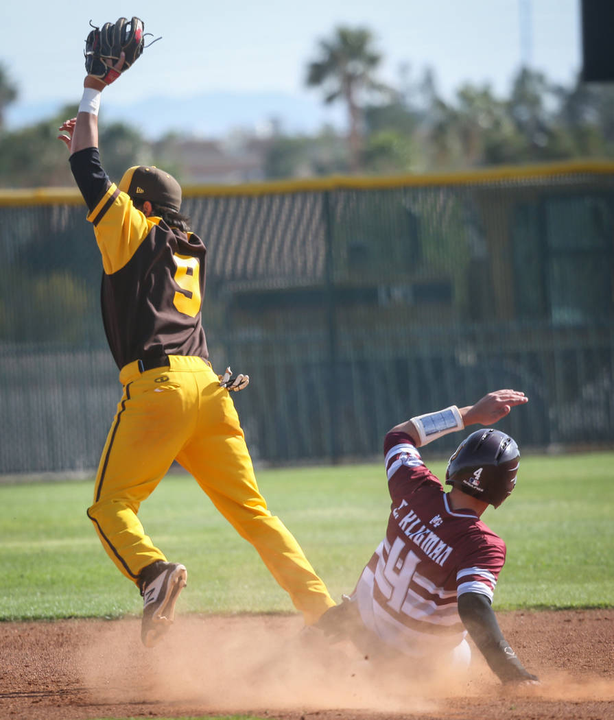 Bonanza second baseman Andre Holloway (9) catches the ball as Cimarron-Memorial infielder Elie Kligman (4) slides into second base during a baseball game at Bonanza High School in Las Vegas, Tuesd ...