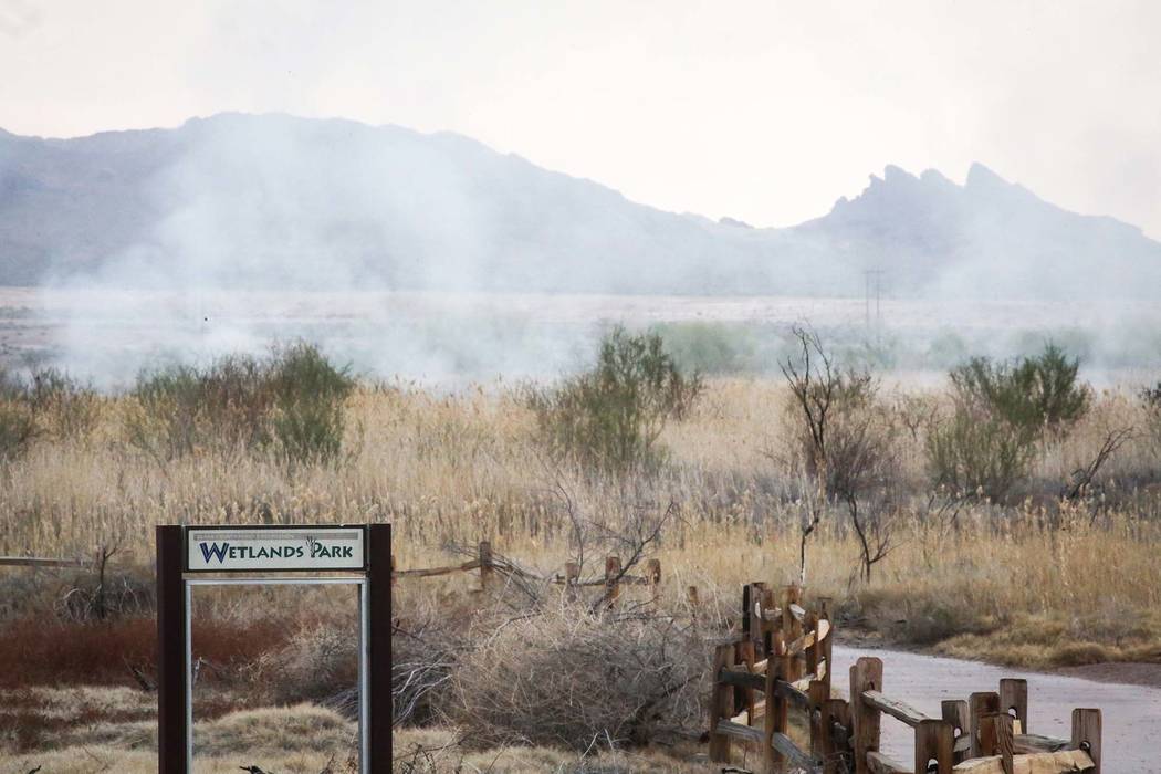 Smoke arises after a brush fire is put out at the Wetlands Park, north of Sam Boyd Stadium, in ...