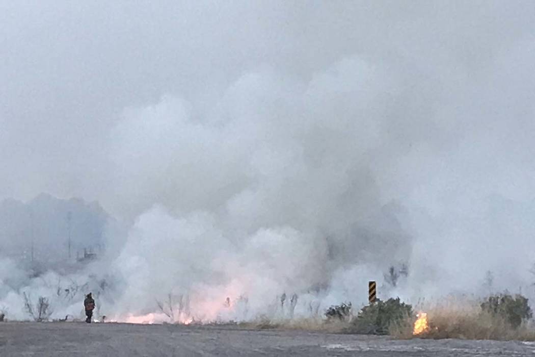 Smoke from a brush fire billows into the air at the Wetlands Park, north of Sam Boyd Stadium, e ...