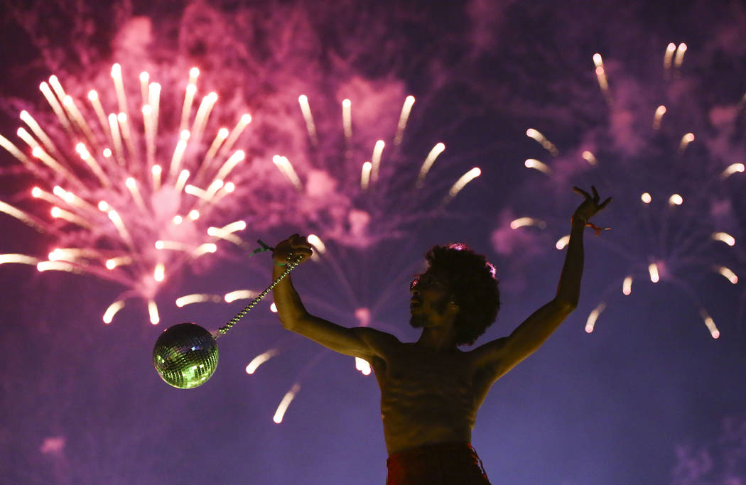 Deven Williams of the Kalliope dances on an art car as fireworks go off during the third day of ...