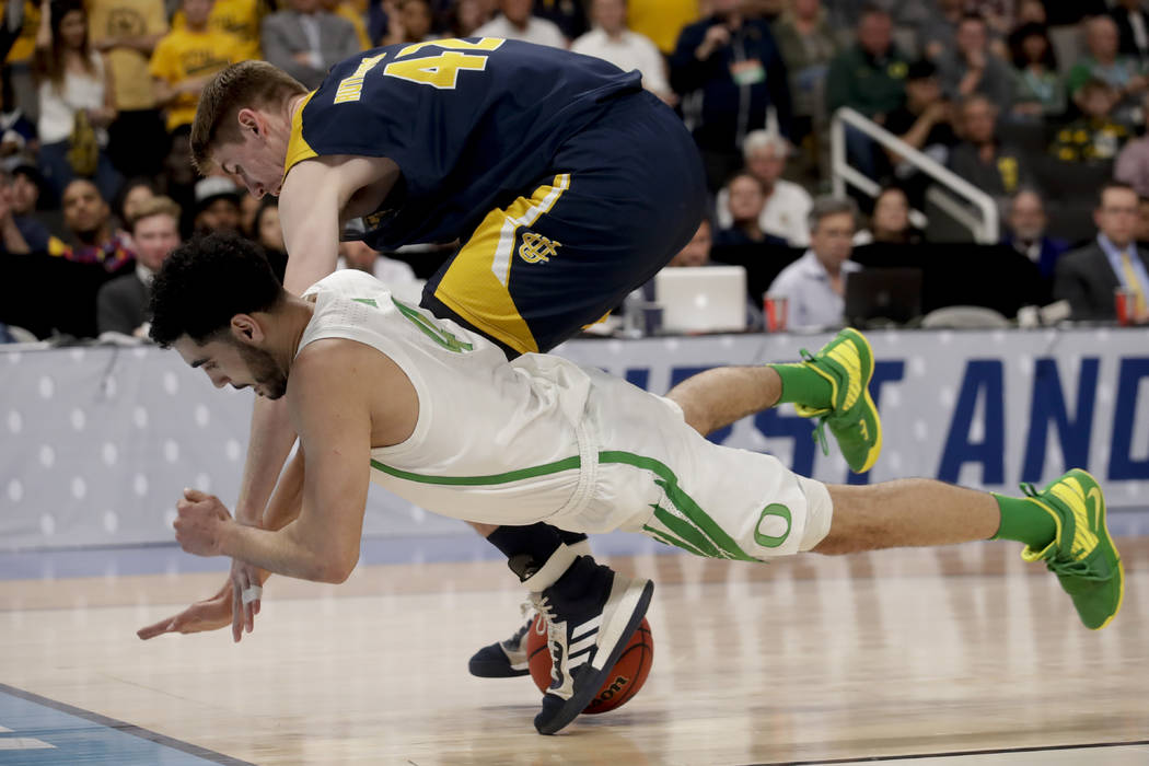 UC Irvine forward Tommy Rutherford, top, and Oregon guard Ehab Amin vie for a loose ball during ...
