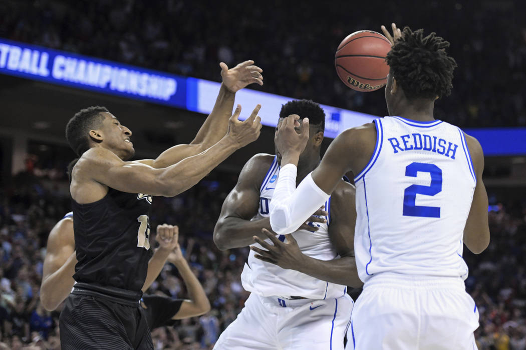 Central Florida guard Aubrey Dawkins, left, battles for a rebound against Duke's Zion Williamson, and Cam Reddish (5) after missing a potential game-winning tip-in during the second half of a seco ...