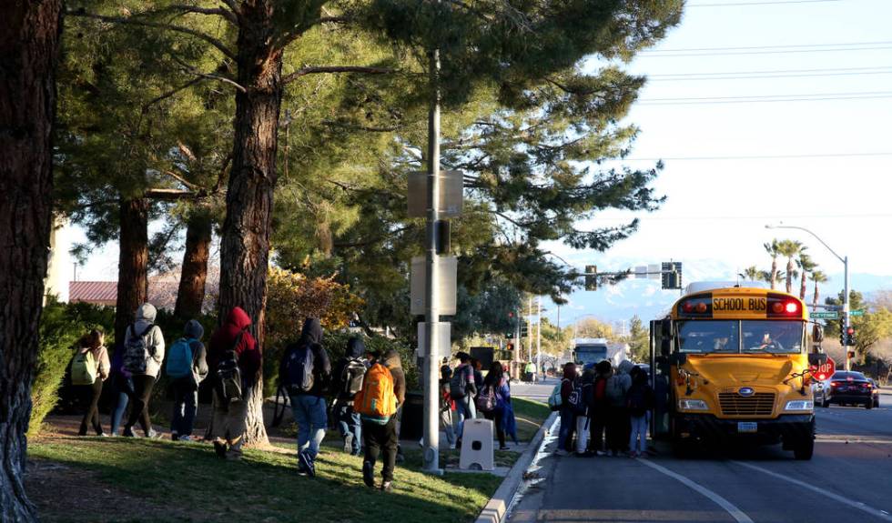 Students board the school bus on Soaring Gulls Drive near Cheyenne Avenue at Desert Shores Vill ...