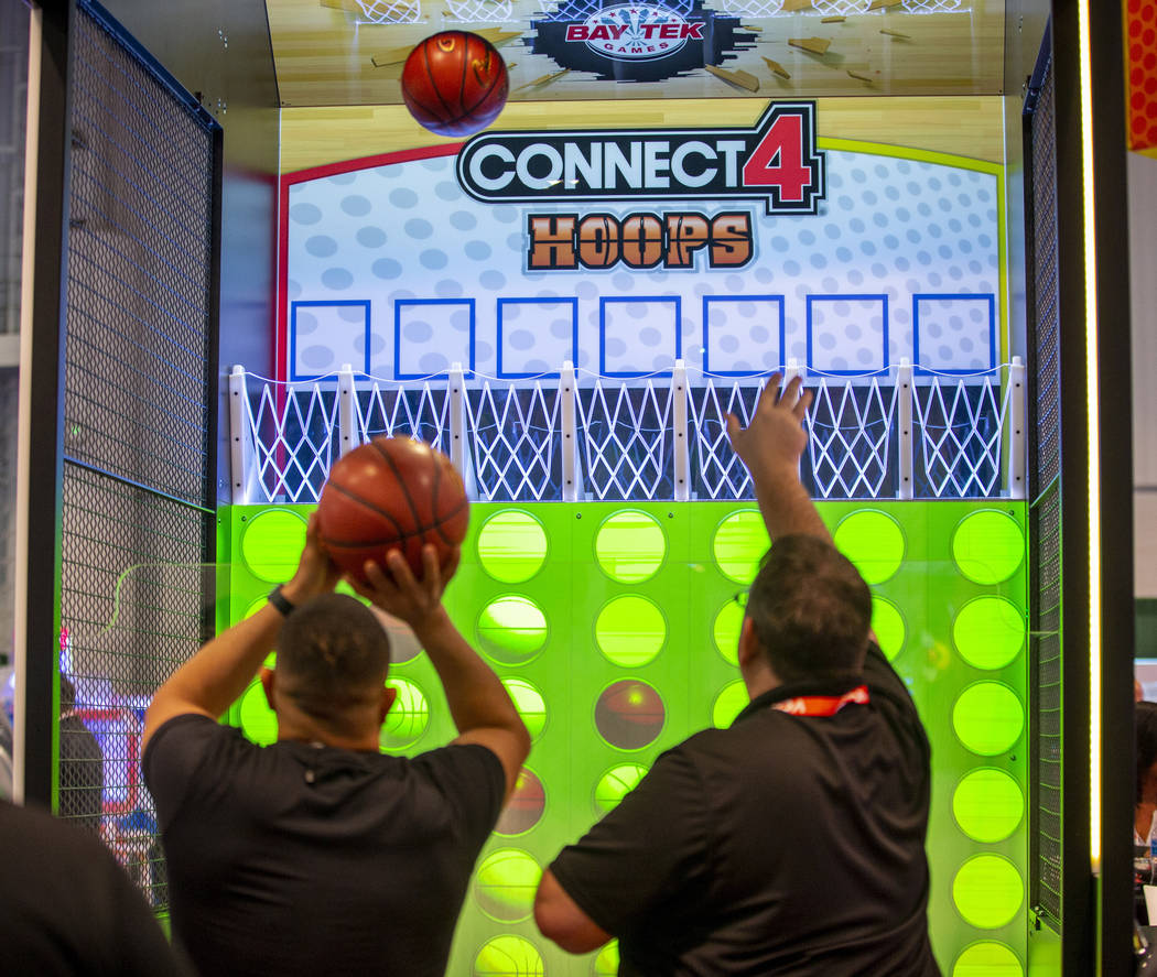 Attendees shoot baskets in a Connect 4 Hoops game during the Amusement Expo at the Las Vegas Co ...