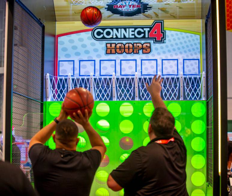 Attendees shoot baskets in a Connect 4 Hoops game during the Amusement Expo at the Las Vegas Co ...