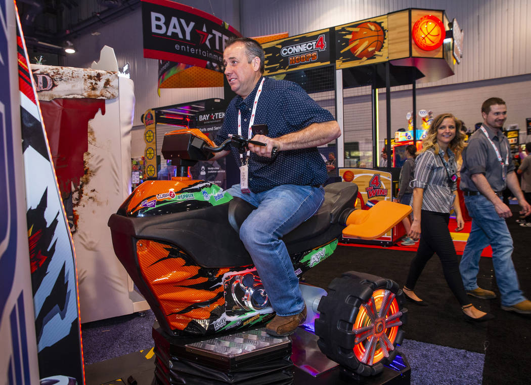 Kyle Pulsifer with Fiddlers Fun Center tests out an ATV driving game during the Amusement Expo ...