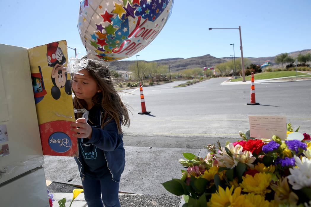 Evelyn Yoshimori, 7, signs a memorial on South Fort Apache Road at Faiss Park in Las Vegas Wedn ...