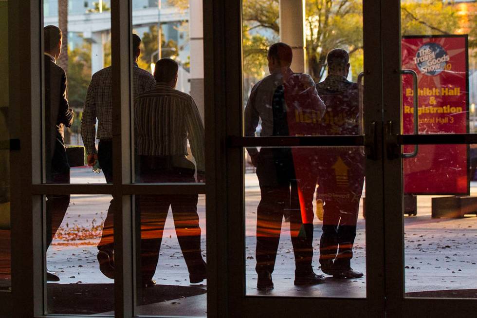 Plainclothes police officers walk out of the Las Vegas Convention and Visitors Authority office ...