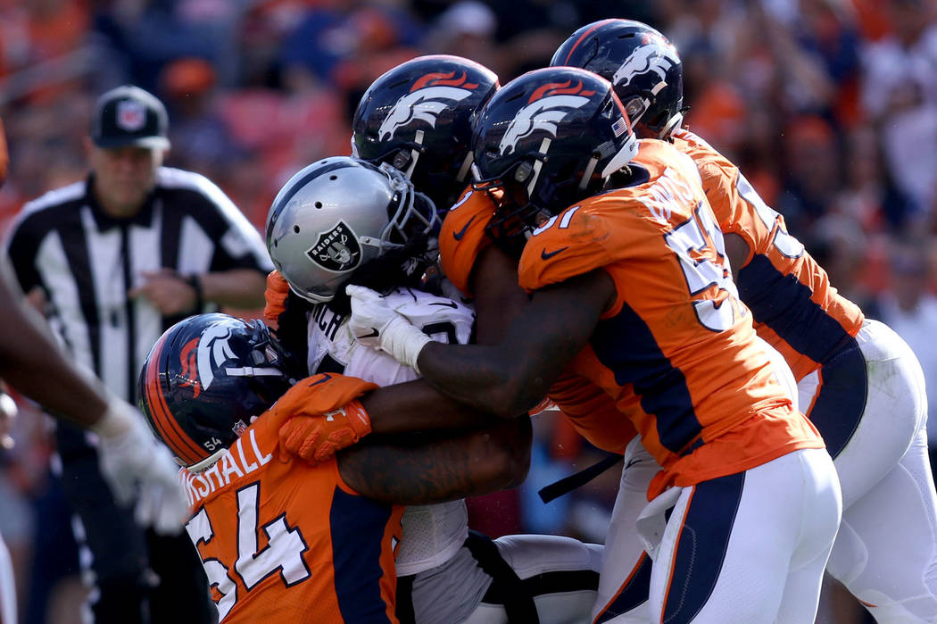 Oakland Raiders running back Marshawn Lynch (24) is tackled by Denver Broncos linebacker Brando ...