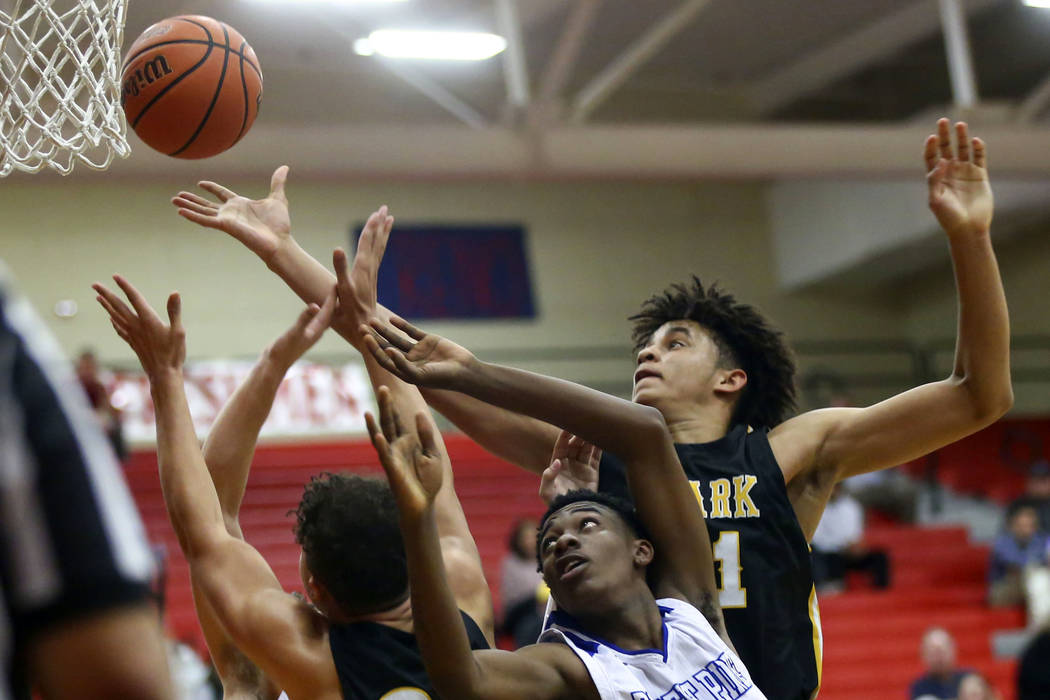 Clark's Jalen Hill, right, battles for a rebound against Desert Pines' Dayshawn Wiley (2) durin ...